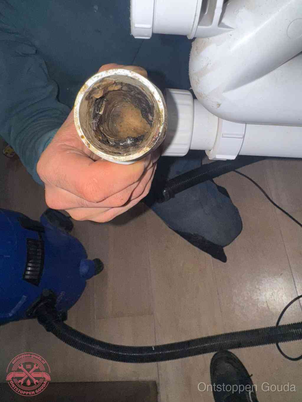 Een losgekoppeld afvoerbuisstuk dat van binnen volledig is dichtgeslibd, het gevolg van een verstopping te lang laten zitten in Gouda