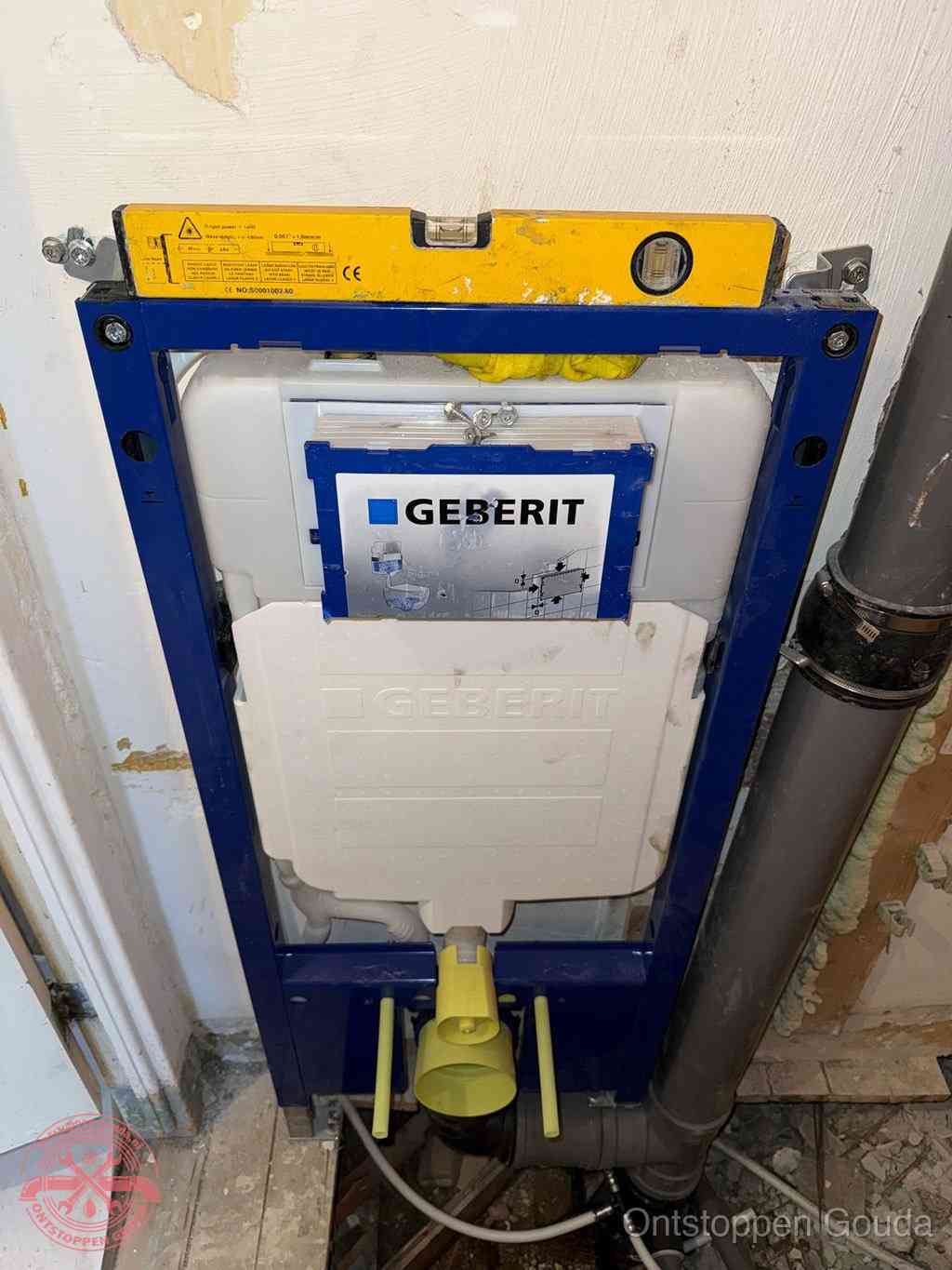 Een Geberit inbouwreservoir met frame voor een hangtoilet tegen de wand, met de afvoerbocht naar de vloer, kenmerkend voor een verstopt hangtoilet in Gouda