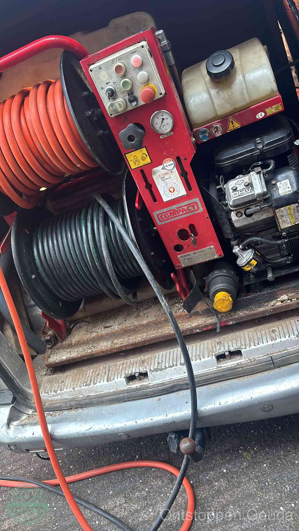 Een rood hogedruk-rioolreinigingstoestel in de laadbak van de bedrijfsbus, apparatuur voor een hardnekkige afvoerverstopping in Gouda