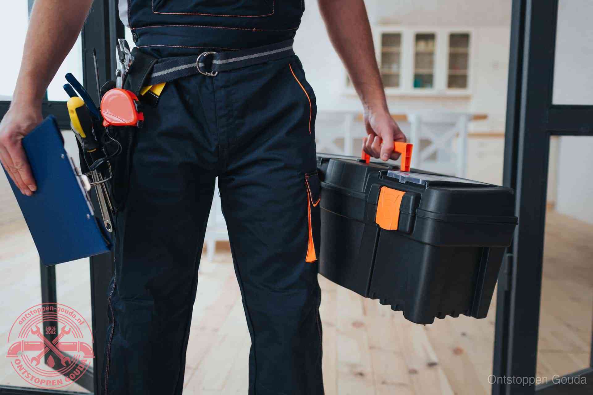 Een monteur met gereedschapsriem en klembord, klaar om een transparante prijs voor het wc ontstoppen in Gouda te geven