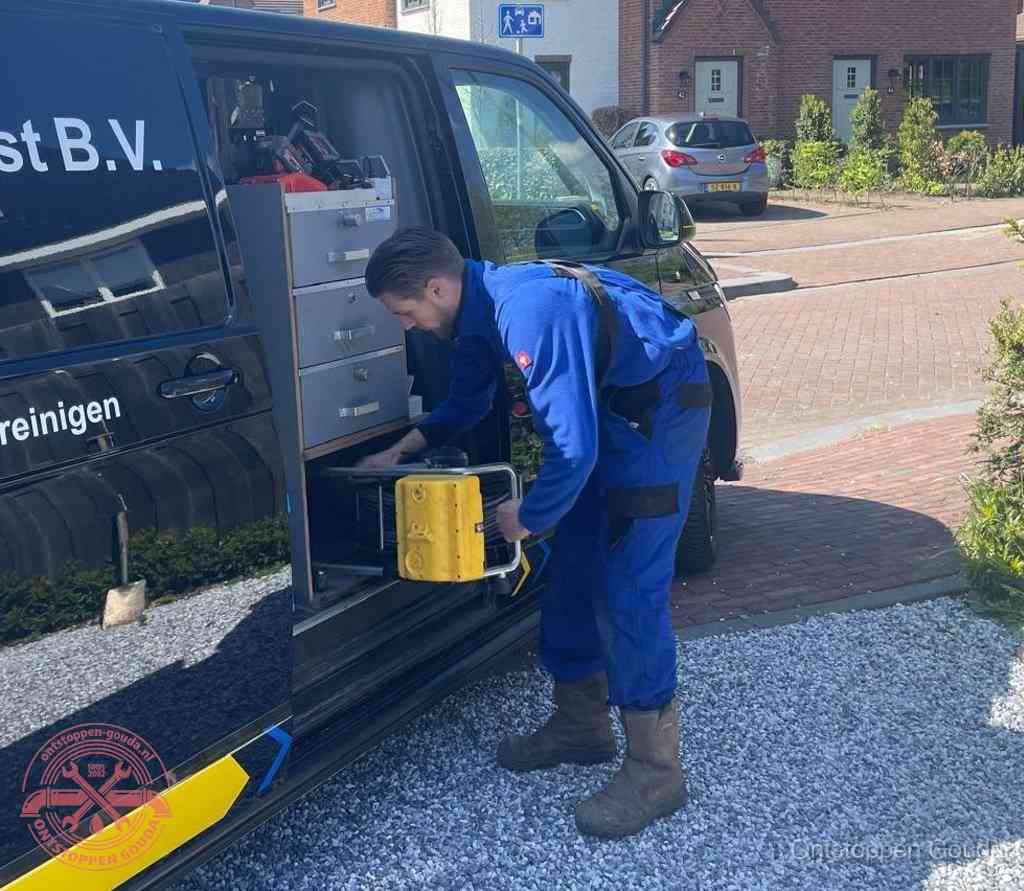 Een monteur pakt apparatuur uit de bedrijfsbus voor service aan huis, het moment om een professional in te schakelen voor een verstopte wc in Gouda